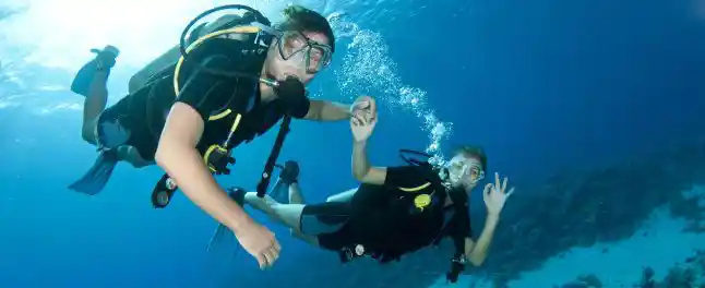 diver couple holding hands underwater